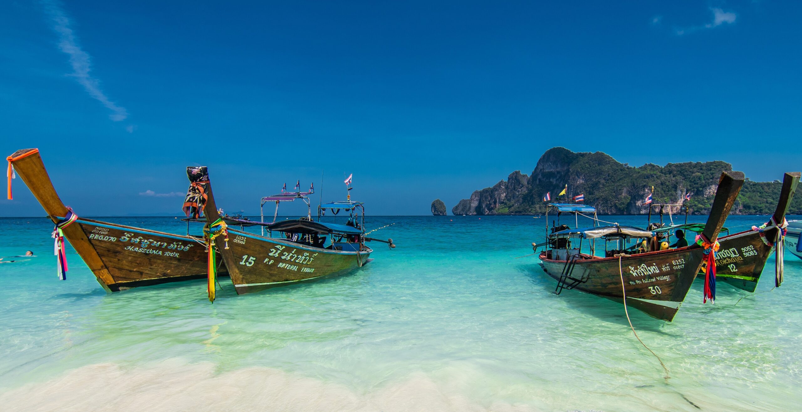 Long Tail Boats parking at the white and beach